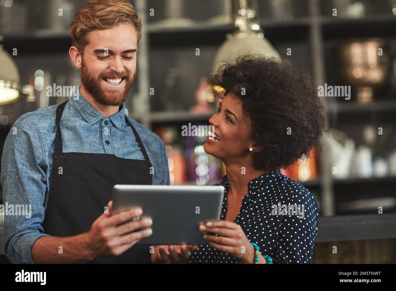 Gestione del proprio bar sulla rete wireless. i giovani dipendenti di una caffetteria che utilizzano un tablet digitale insieme. Foto Stock