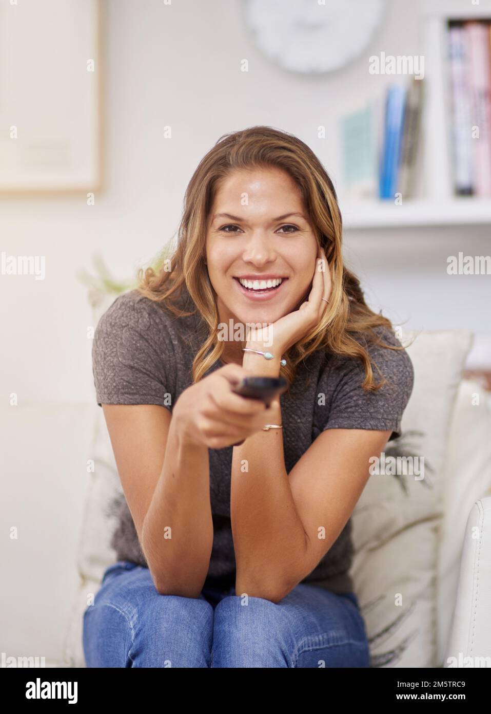 Questo sembra un buon spettacolo da guardare. una giovane donna che trascorre un weekend rilassante a casa guardando la tv. Foto Stock