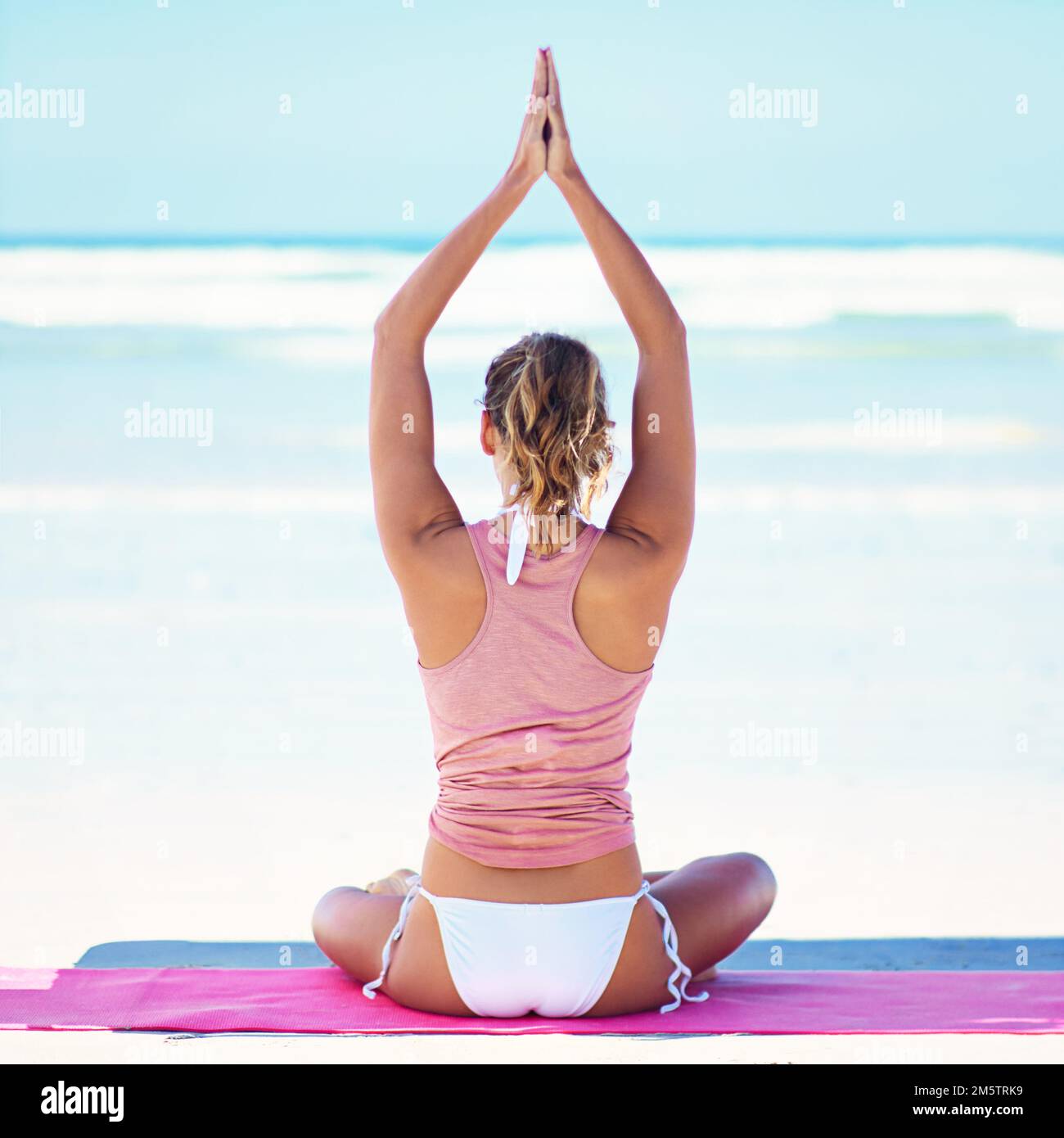 La meditazione è la chiave dell'illuminazione. una giovane donna che fa yoga in spiaggia. Foto Stock