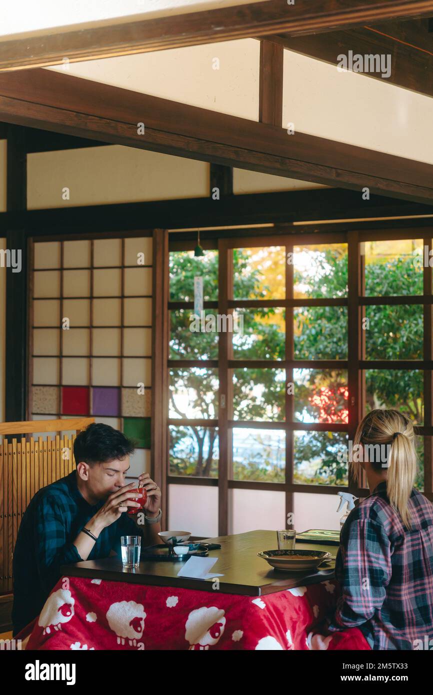 Turista straniero che ha un pasto in una tradizionale casa di riposo giapponese Foto Stock