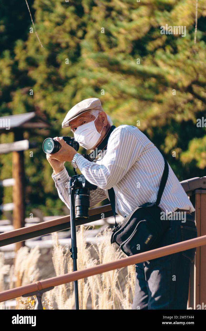 Un fotografo anziano che scatta foto al villaggio di Hojyo Foto Stock