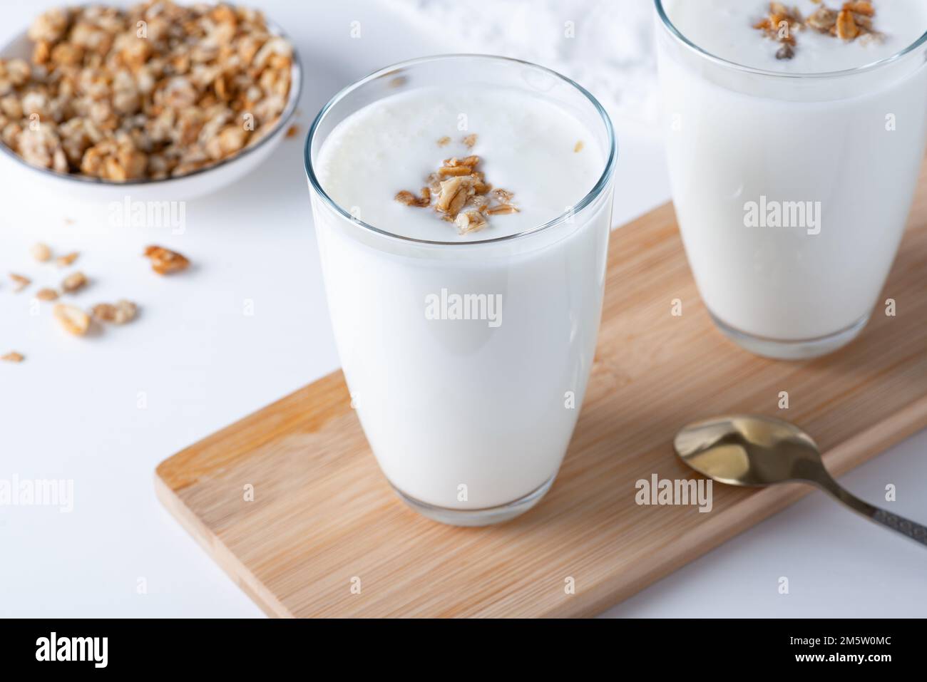 Kefir, latticello o yogurt al granola. Bevanda a base di latticini fermentata fredda probiotica. Foto Stock