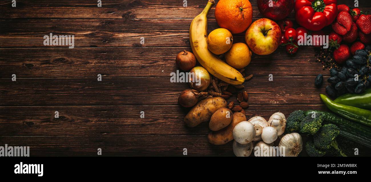 Frutta e verdura su tavola di legno, sfondo, immagine simbolica di cibo sano Foto Stock
