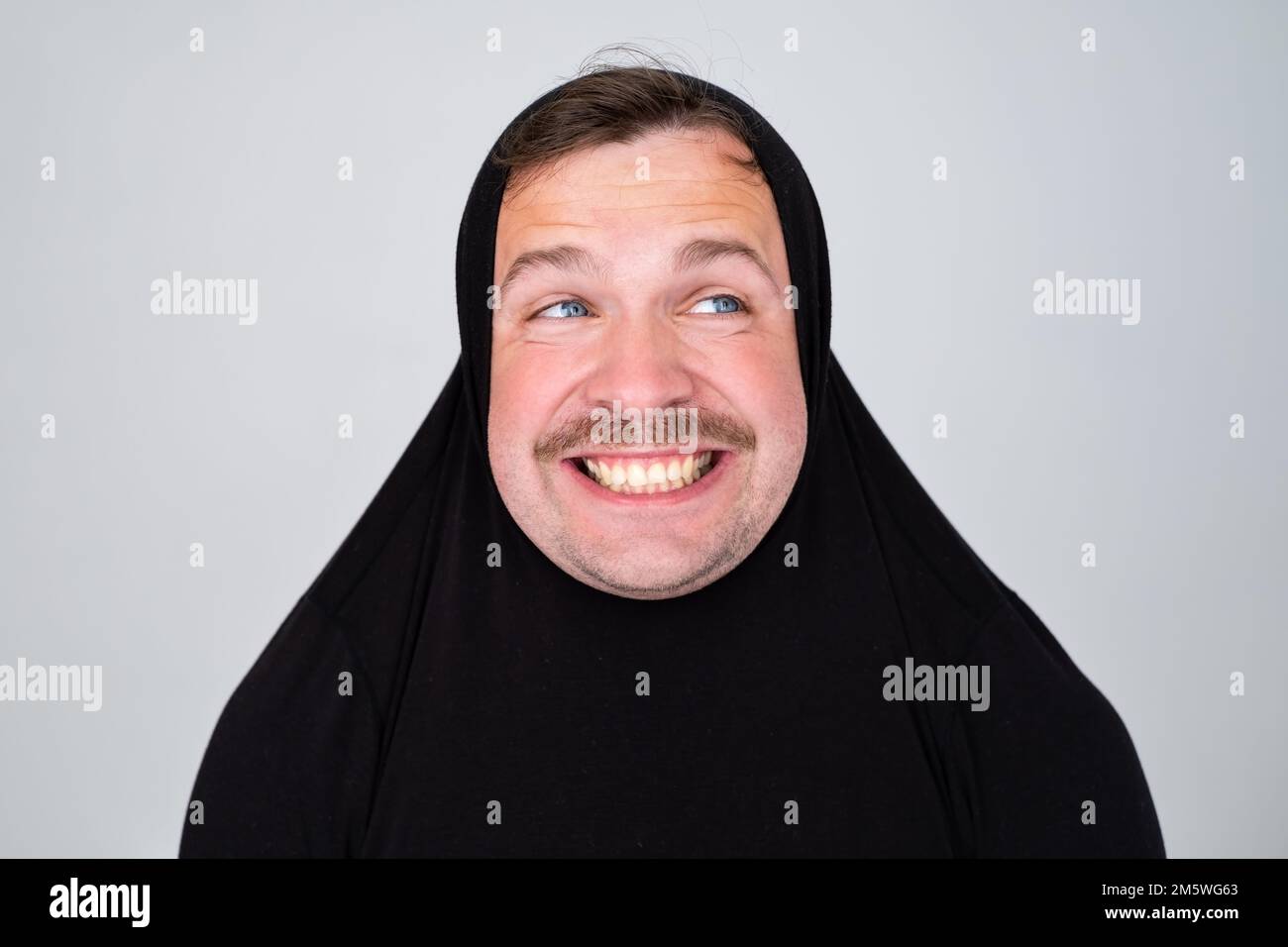 Divertente uomo caucasico coprendo la testa con maglione sorridente allegro e divertente. Foto Stock
