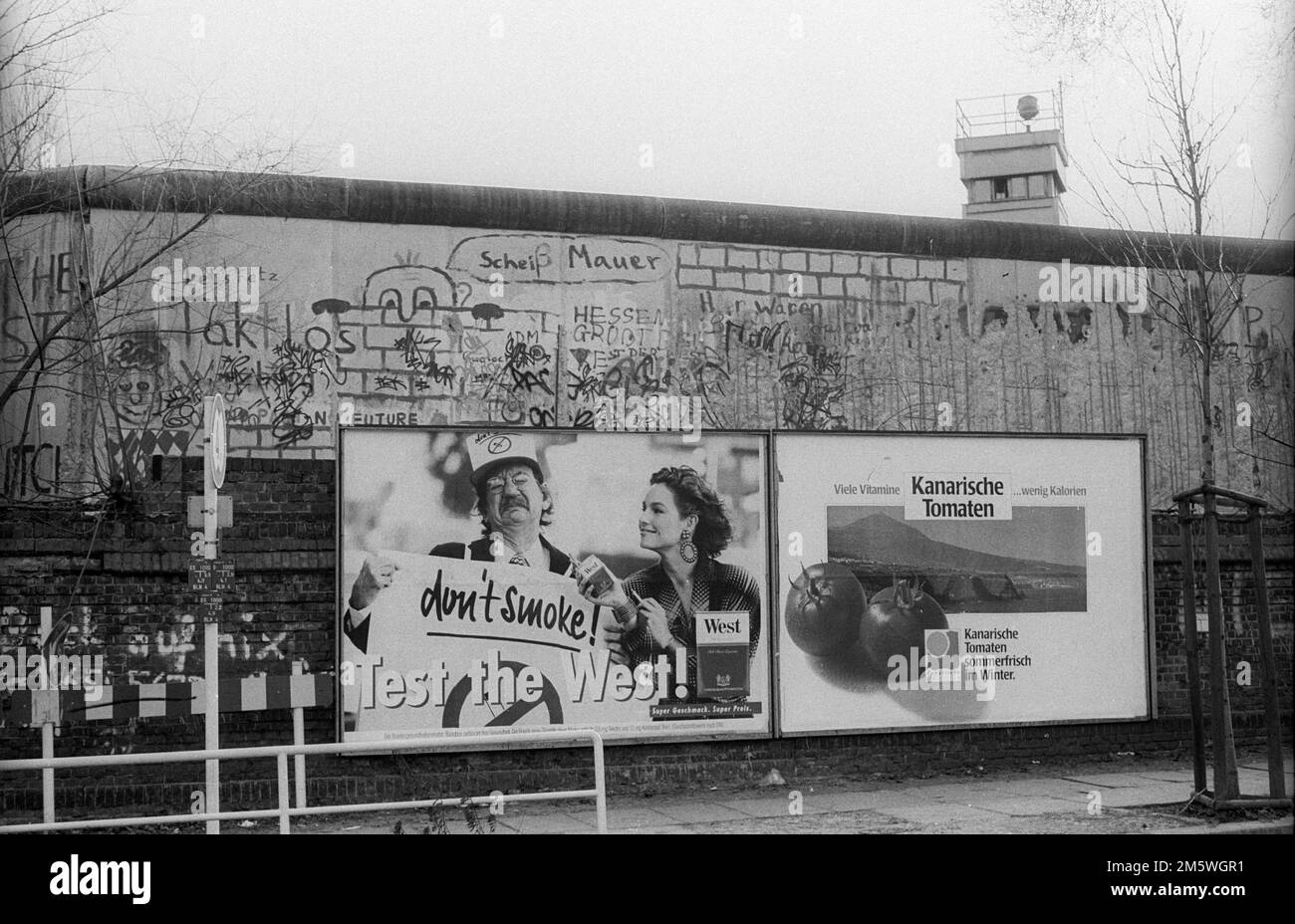 GDR, Berlino, 04. 02. 1990, scheda pubblicitaria al muro Liesenstrasse, sullo sfondo una torre di guardia, C Rolf Zoellner Foto Stock
