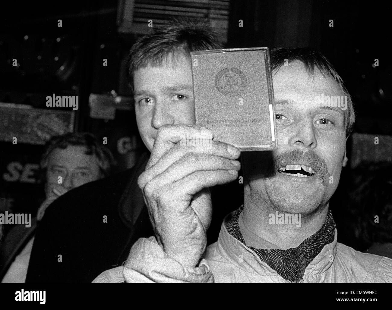 GDR, Berlino, 09. 11. 1989, apertura del muro di Berlino, Celebrazione su KuDamm (Kurfuerstendamm), il cittadino della RDT mostra la sua carta d'identità della RDT Foto Stock