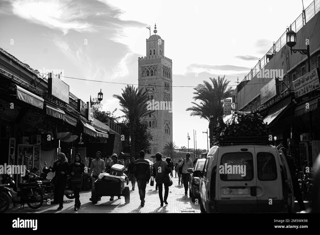 Strada che conduce verso la Moschea di Koutoubia, Marrakech. Minareto storico e vita di strada Foto Stock