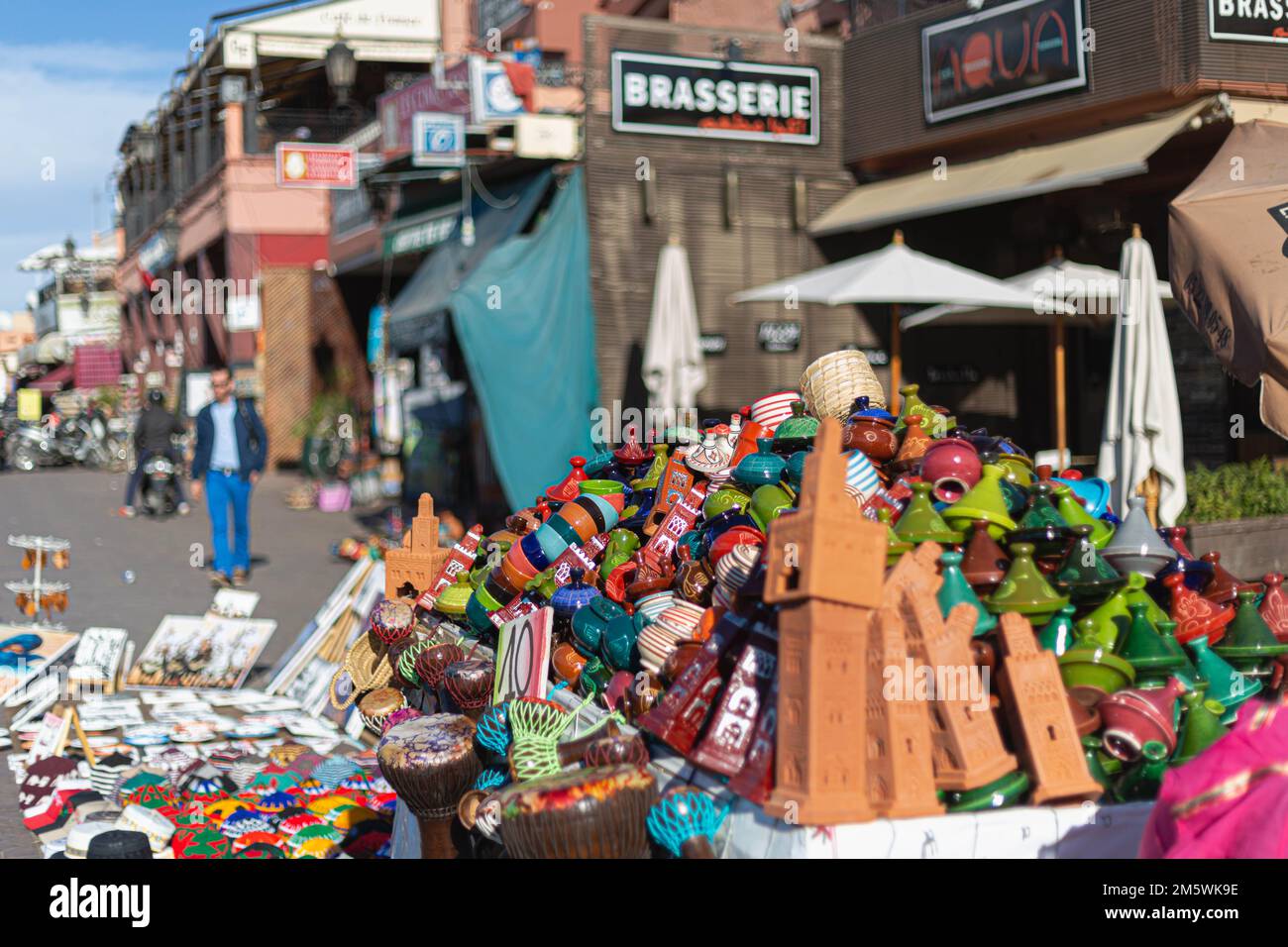 Vivace e colorata scena di strada, probabilmente mercato di Marrakech. Negozi, merci in mostra, gente che cammina. Foto Stock