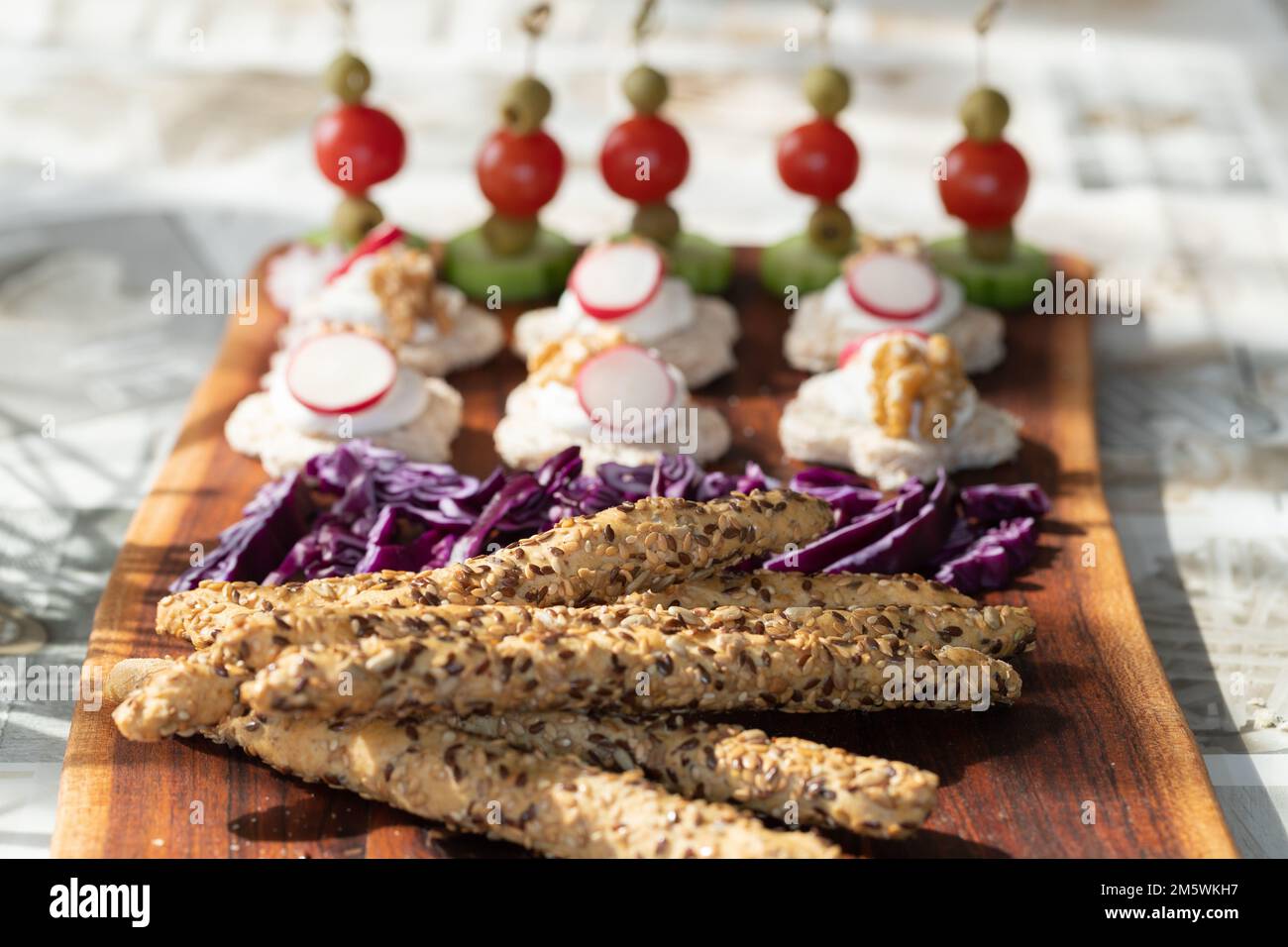 Assortimento di grissini e mini canapè colorati su una tavola di legno. Stuzzichini. Foto Stock
