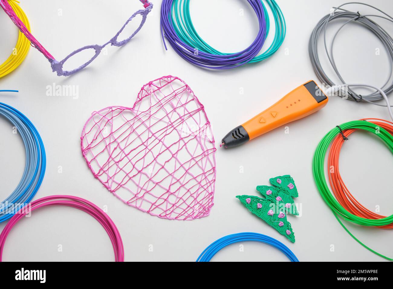 3D penna. Stampa con filamento in filo di plastica colorato. Bambino che fa  un Natale tre, disegno a forma di cuore con 3D penna. Grafica, robotica.  VAPORE, STELO e Foto stock -