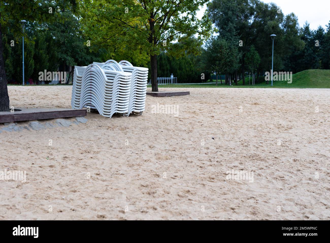 Dopo la stagione estiva, i lettini sulla spiaggia della città si stackano accanto allo stagno. La fine dell'attività ricreativa all'inizio dell'autunno Foto Stock