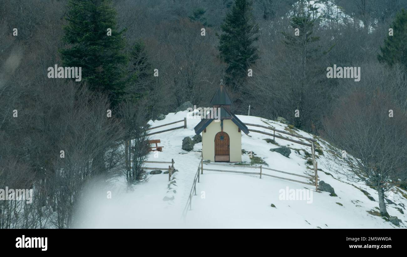 Una cappella circondata da foreste innevate Foto Stock