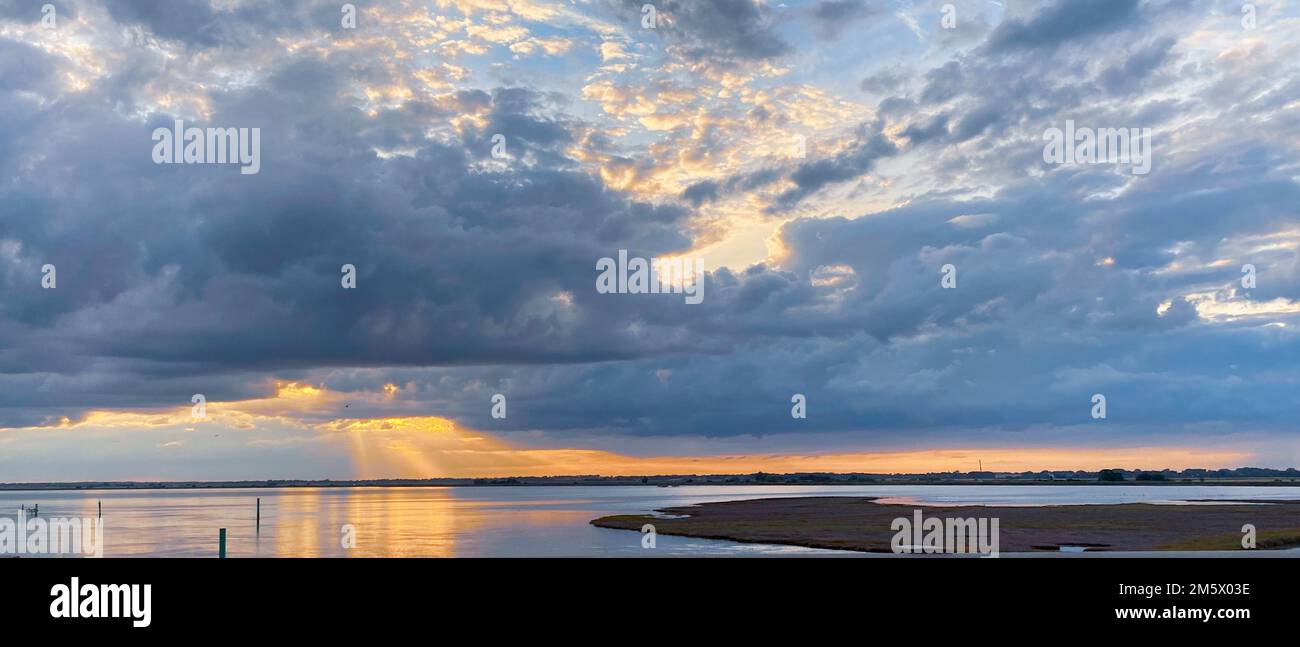 Tramonto panoramico sul lago della riserva naturale in una giornata nuvolosa, la costa del Norfolk in Inghilterra Foto Stock