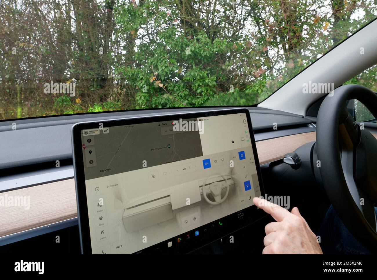 Display di bordo dell'auto elettrica. Veicolo elettrico Tesla con guida a destra e cruscotto con display a bordo Foto Stock