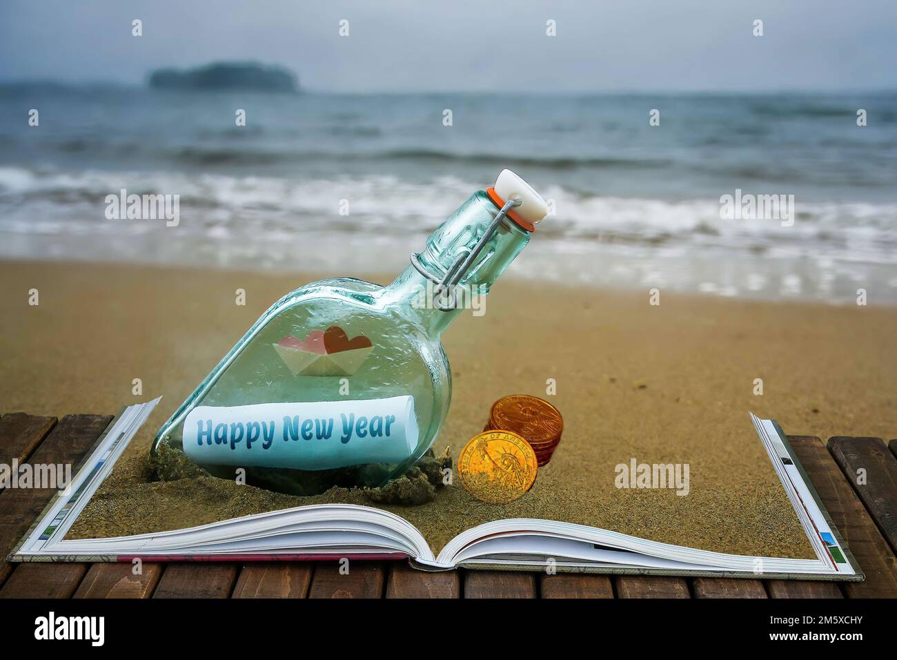 Buon anno auguri in bottiglia fuori sulla spiaggia Foto Stock