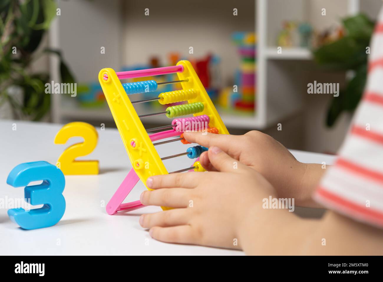 Un bambino piccolo impara a contare su abaco, matematica, aritmetica per i bambini. Foto Stock