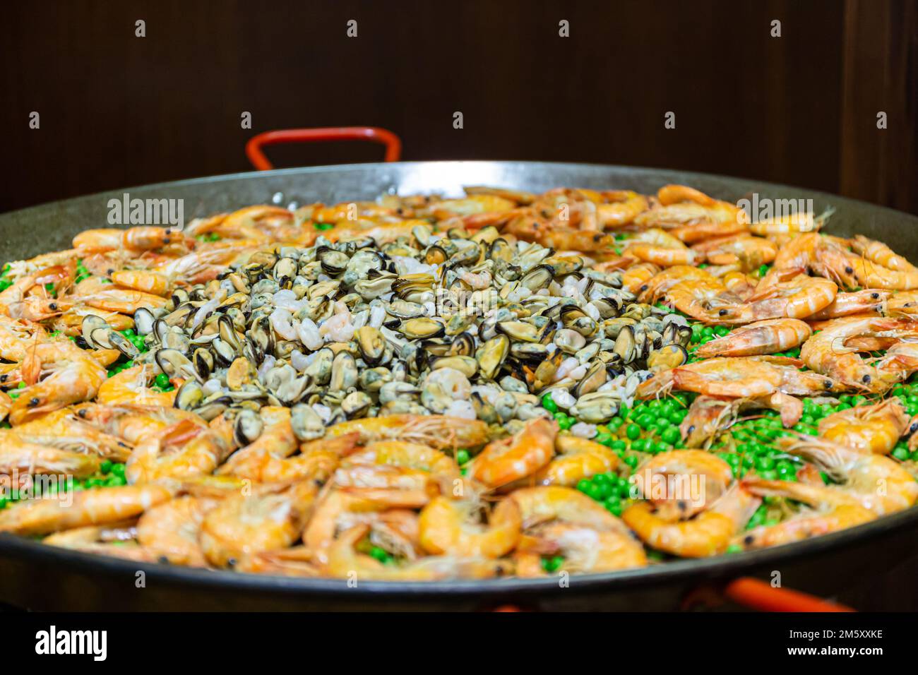 ampia paella con piselli e frutti di mare in stufa Foto Stock