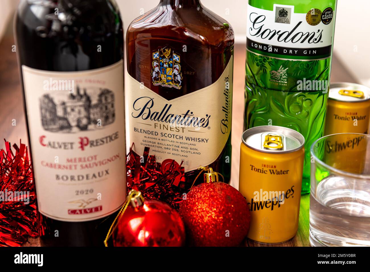Londra. UK- 12.31.2022. Vino rosso Bordeaux, Scotch Whisky di Ballantine, Gin di Gordon e acqua tonica di Schweppes. Bevande alcoliche per le feste celebrati Foto Stock