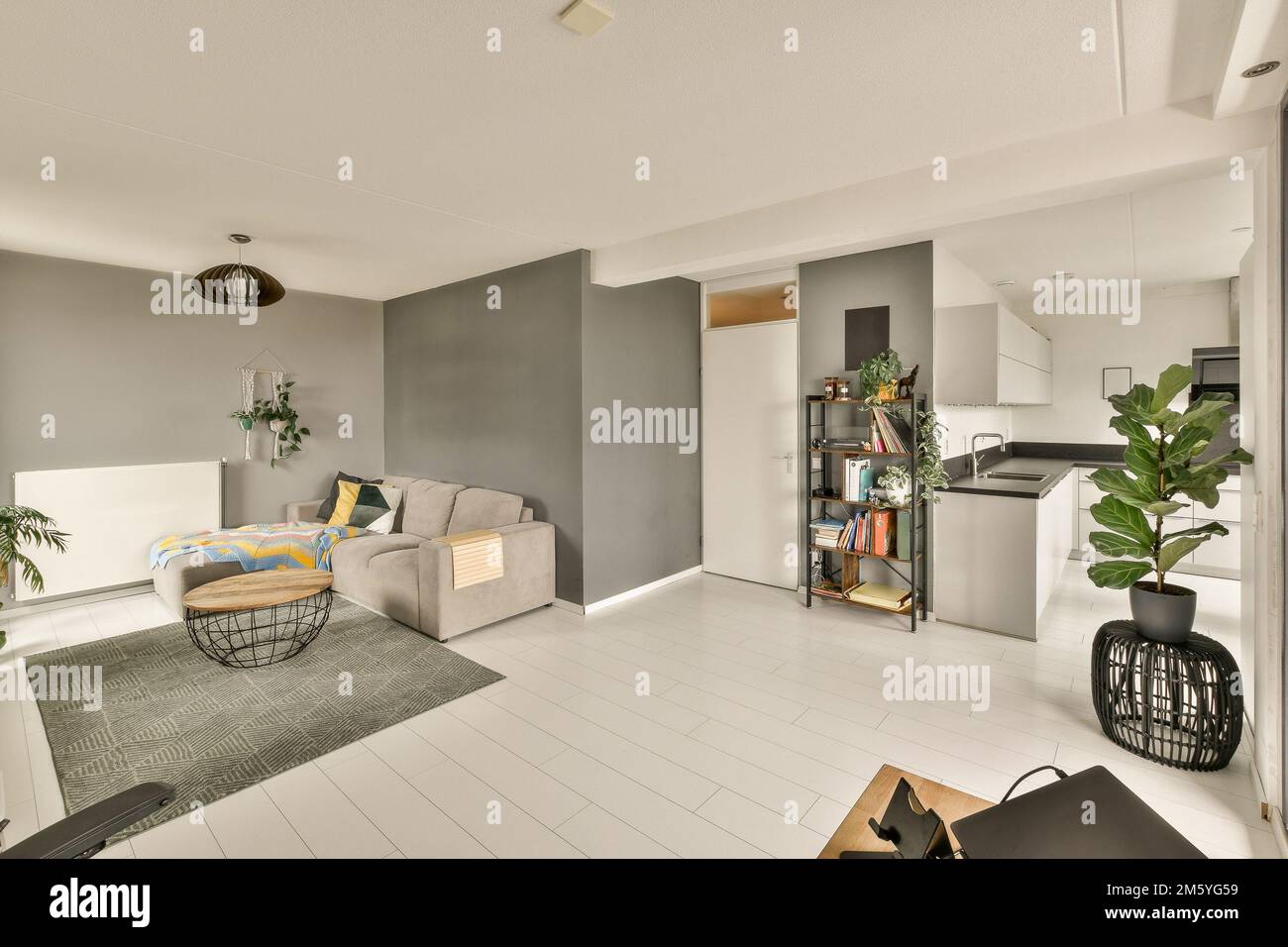 un soggiorno con pareti grigie e pavimento bianco al centro della stanza è  un'area cucina aperta Foto stock - Alamy
