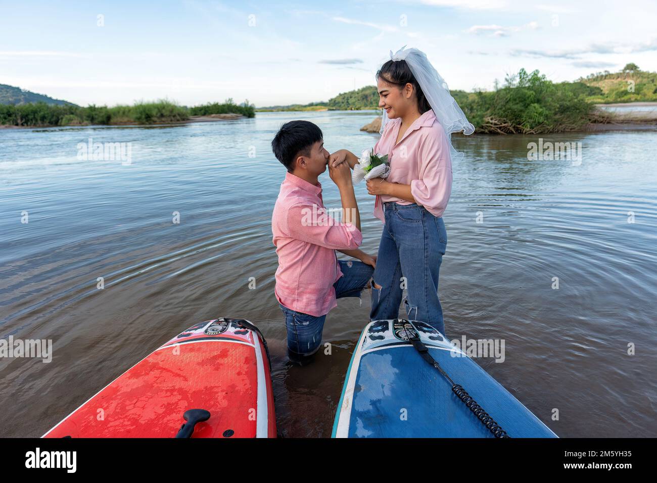 La coppia di amore vela tavola surf sul fiume e ha proposto di sposarsi con un amico ragazza il giorno di San Valentino Foto Stock