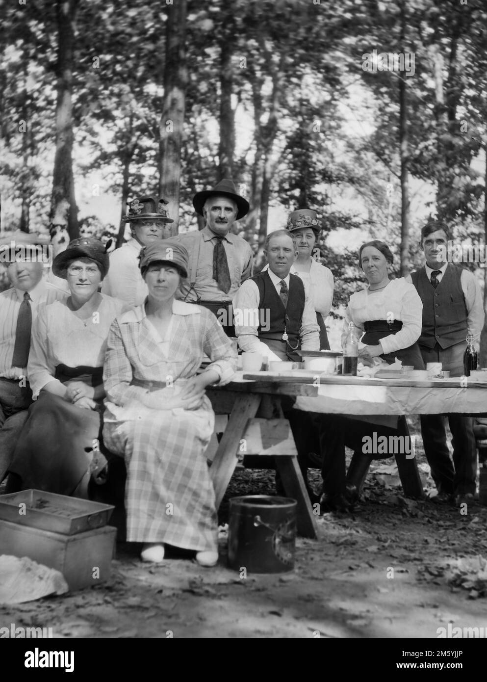 La famiglia si riunisce intorno ad un tavolo da picnic per un ritratto di gruppo, ca. 1910. Foto Stock