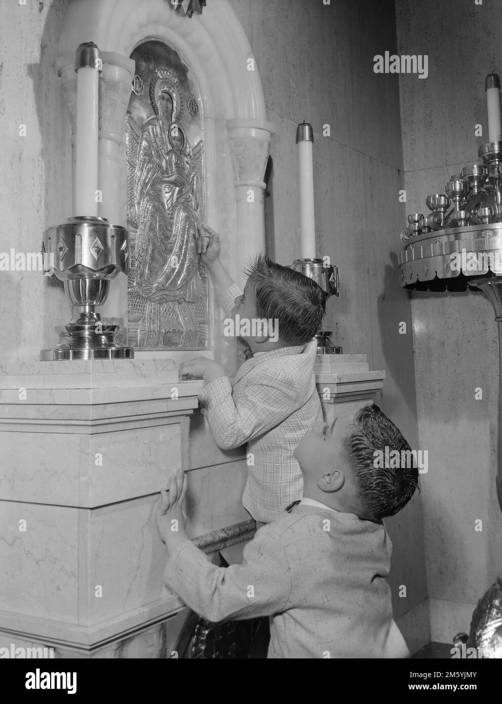 Due ragazzi spuntano un'icona in una chiesa nel sud della California, ca. 1962. Foto Stock