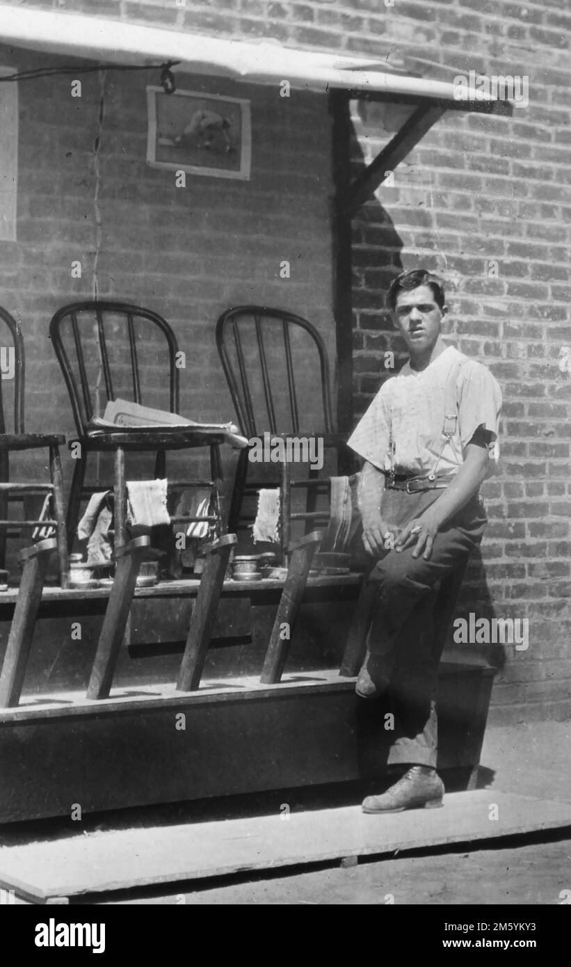 Un lustrascarpe al suo stand all'aperto in una città americana, ca. 1940. Foto Stock