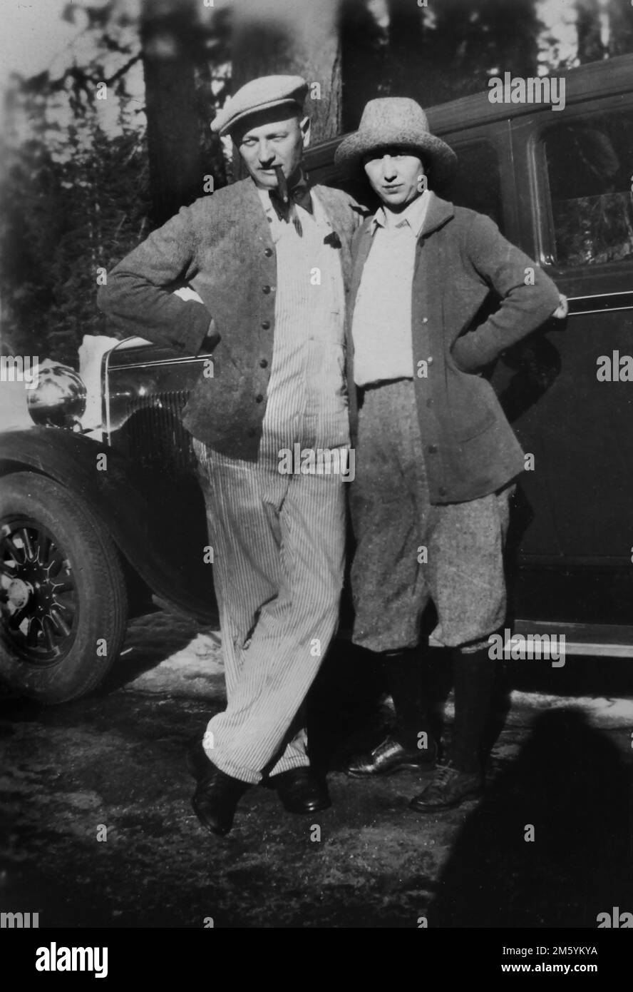 Giovane coppia elegante posa di fronte alla loro auto, mentre viaggiando attraverso il West americano, ca. 1925. Foto Stock