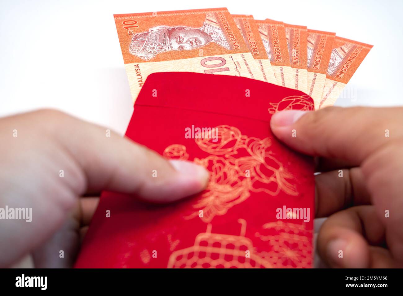 Busta rossa del festival di Capodanno cinese con nota Ringgit Malaysia su sfondo bianco. Festività natalizie, festeggiamenti, buon auspicio, concetto di prosperità. Foto Stock