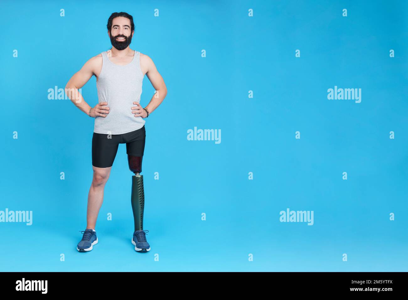 Uomo sorridente in piedi con una protesi della gamba Foto Stock