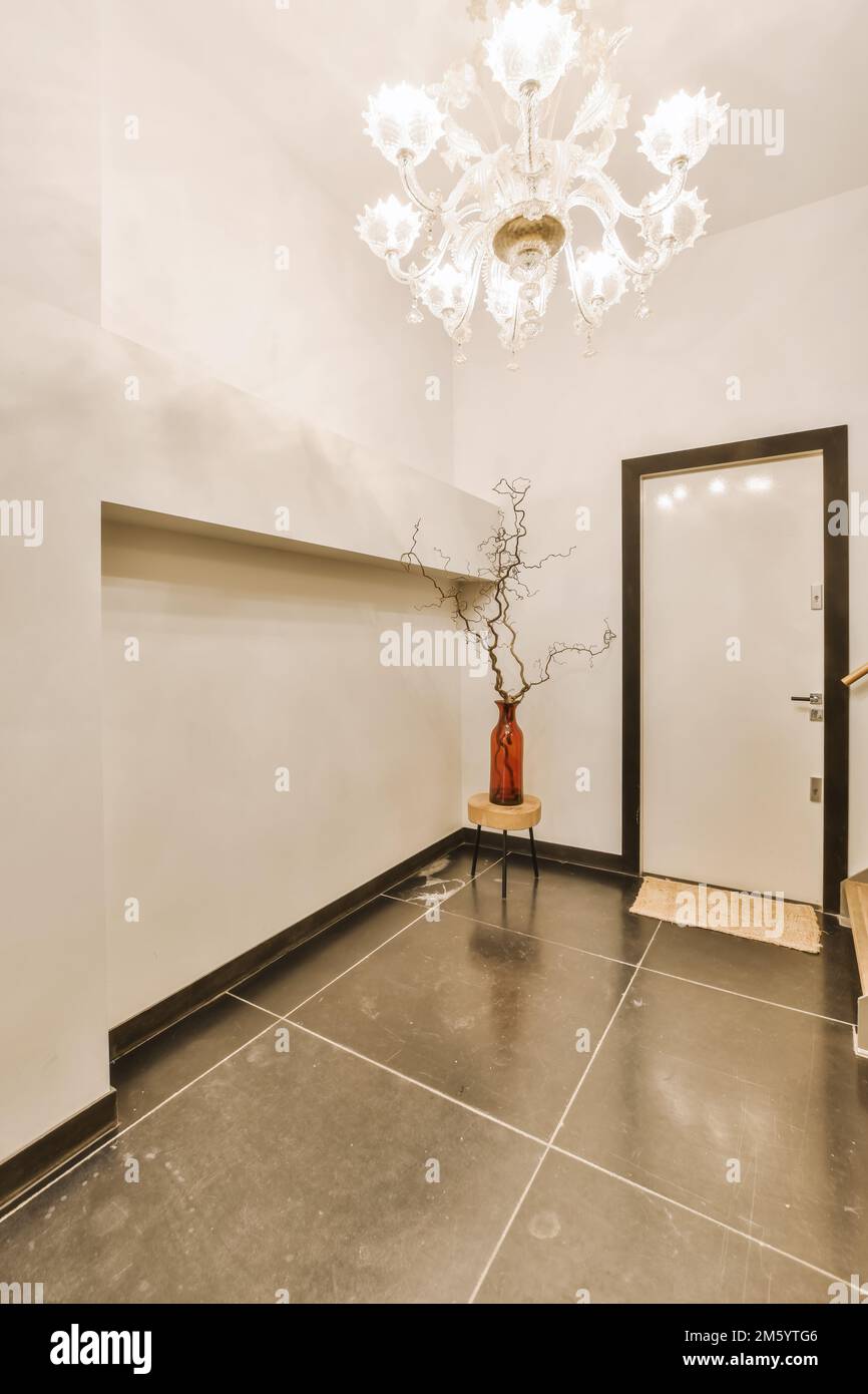 un soggiorno con un chandel e un vaso sul pavimento di fronte alla porta  del bagno Foto stock - Alamy