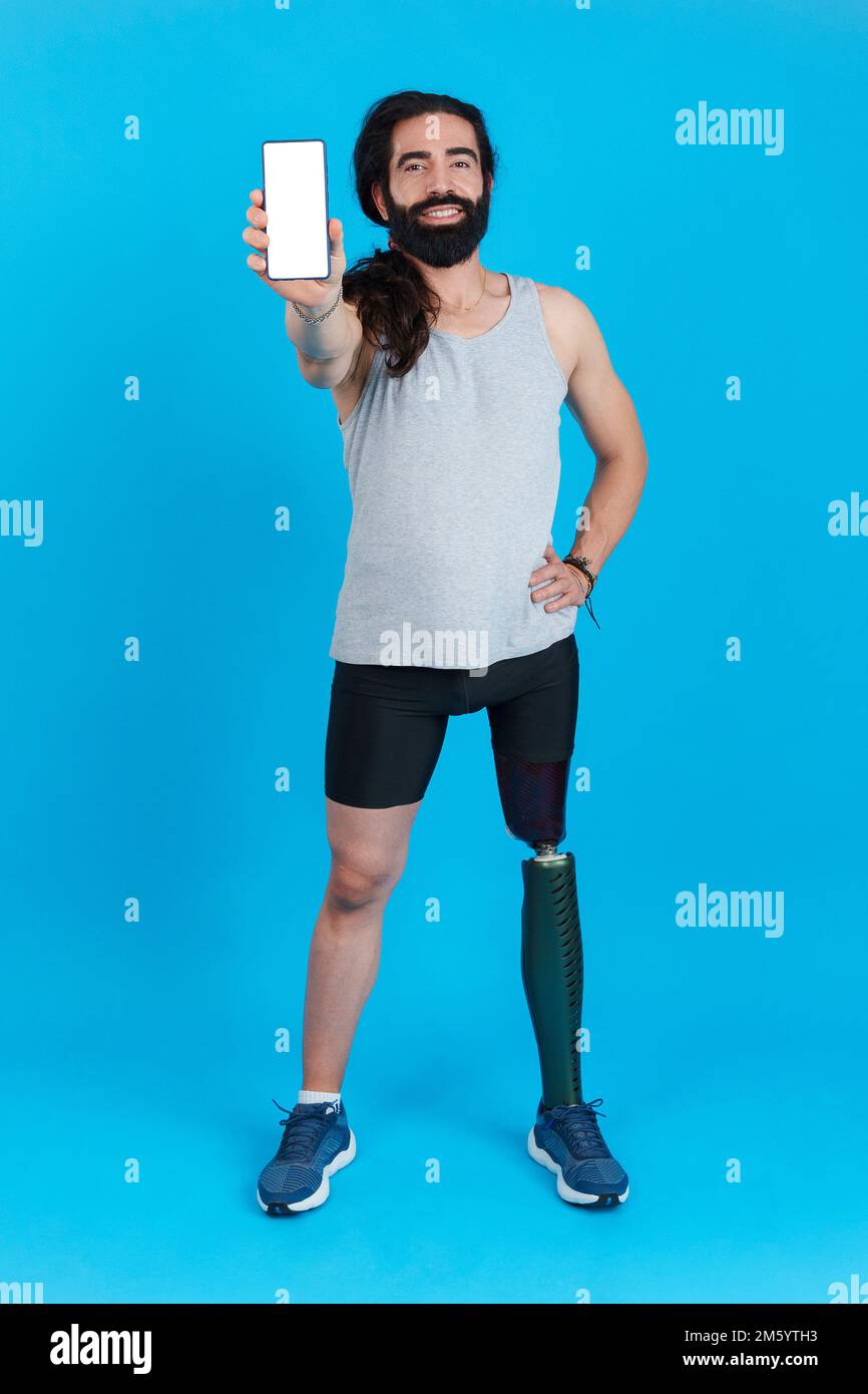 Uomo sorridente con una protesi della gamba che mostra uno schermo mobile Foto Stock