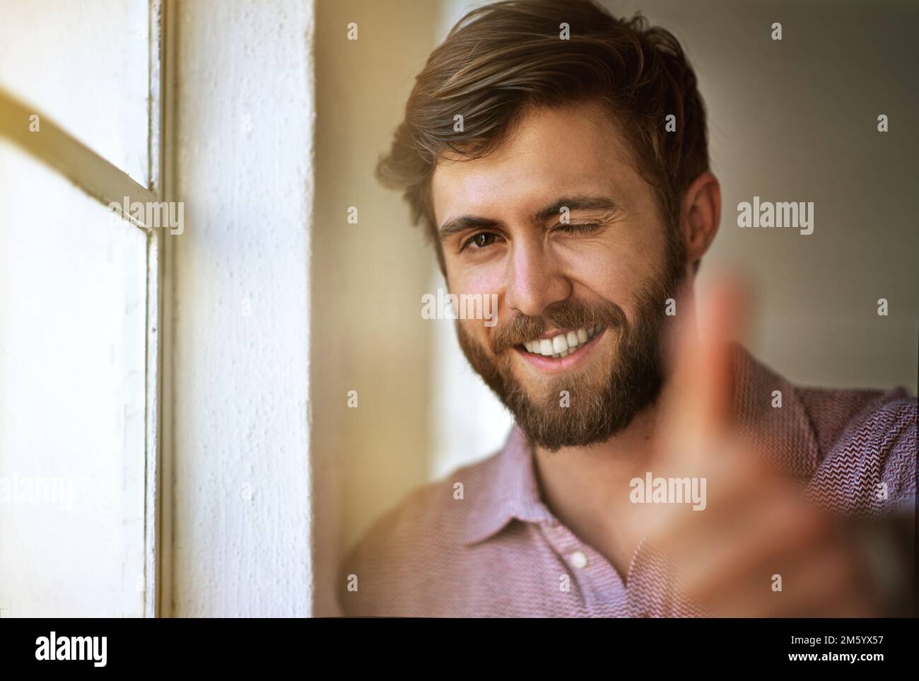 Fatelo con passione o con Per niente. Ritratto corto di un uomo d'affari che dà i pollici in su mentre levandosi in piedi dalla sua finestra dell'ufficio. Foto Stock