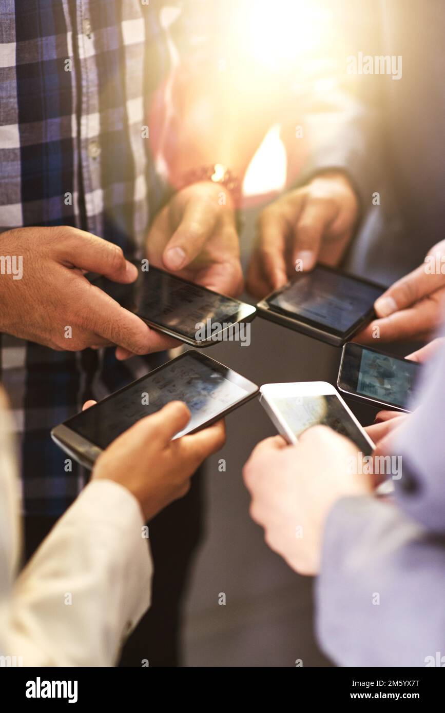 Il lavoro di squadra mantiene viva la connessione. colleghi che utilizzano i loro dispositivi digitali in sincronia. Foto Stock