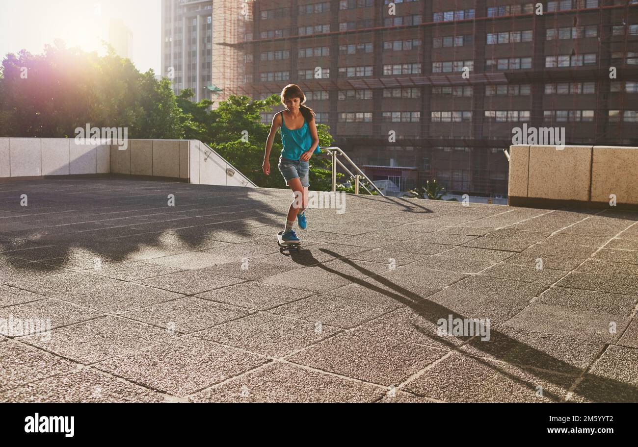 Skate quello che è il vostro super potere. una giovane donna che pattina in città. Foto Stock