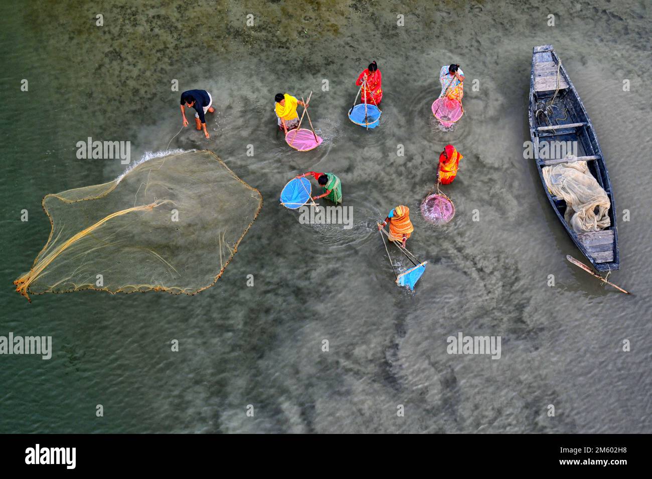 La famiglia dei pescatori ha visto usando le reti colorate durante la pesca sul fiume Marla. Canning si trova a quasi 100 km da Kolkata e nella zona sotto il delta di Sunderban sulle rive occidentali del fiume Matla. La maggior parte degli abitanti del delta sono pescatori che si trovano ad affrontare sfide in quanto l'oceano inghiottisce terra nella più grande foresta di mangrovie del mondo, esseri umani e tigri vengono schiacciati in uno spazio sempre più ridotto nei Sundarbans indiani, con conseguenze letali. Il livello del mare è aumentato in media di 3 - 5 centimetri all'anno negli ultimi due decenni nei Sundarbans, portando ad uno dei più veloci Foto Stock