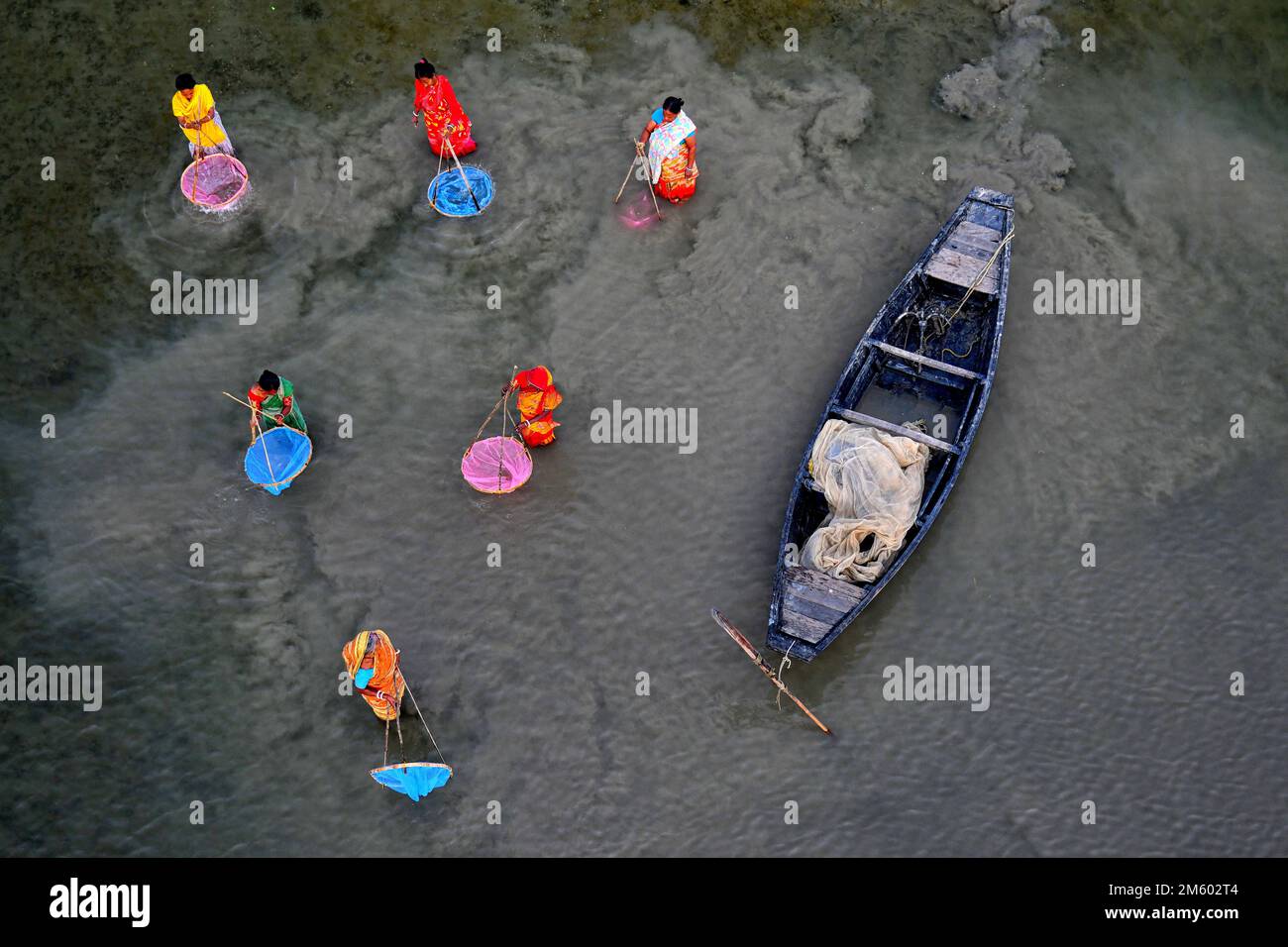 La famiglia dei pescatori ha visto usando le reti colorate durante la pesca sul fiume Marla. Canning si trova a quasi 100 km da Kolkata e nella zona sotto il delta di Sunderban sulle rive occidentali del fiume Matla. La maggior parte degli abitanti del delta sono pescatori che si trovano ad affrontare sfide in quanto l'oceano inghiottisce terra nella più grande foresta di mangrovie del mondo, esseri umani e tigri vengono schiacciati in uno spazio sempre più ridotto nei Sundarbans indiani, con conseguenze letali. Il livello del mare è aumentato in media di 3 - 5 centimetri all'anno negli ultimi due decenni nei Sundarbans, portando ad uno dei più veloci Foto Stock