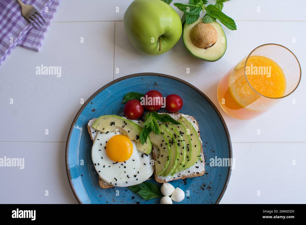 Piatto salutare per la colazione, succo d'arancia, formaggio cremoso, avocado e pane dietetico con uova. Foto Stock