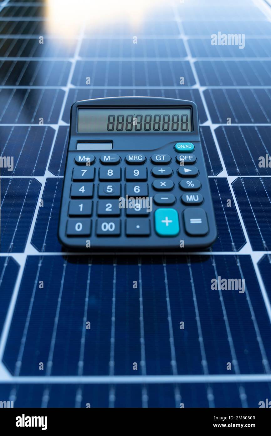 Concetto di risparmio energetico con pannelli solari e calcolatrice Foto Stock