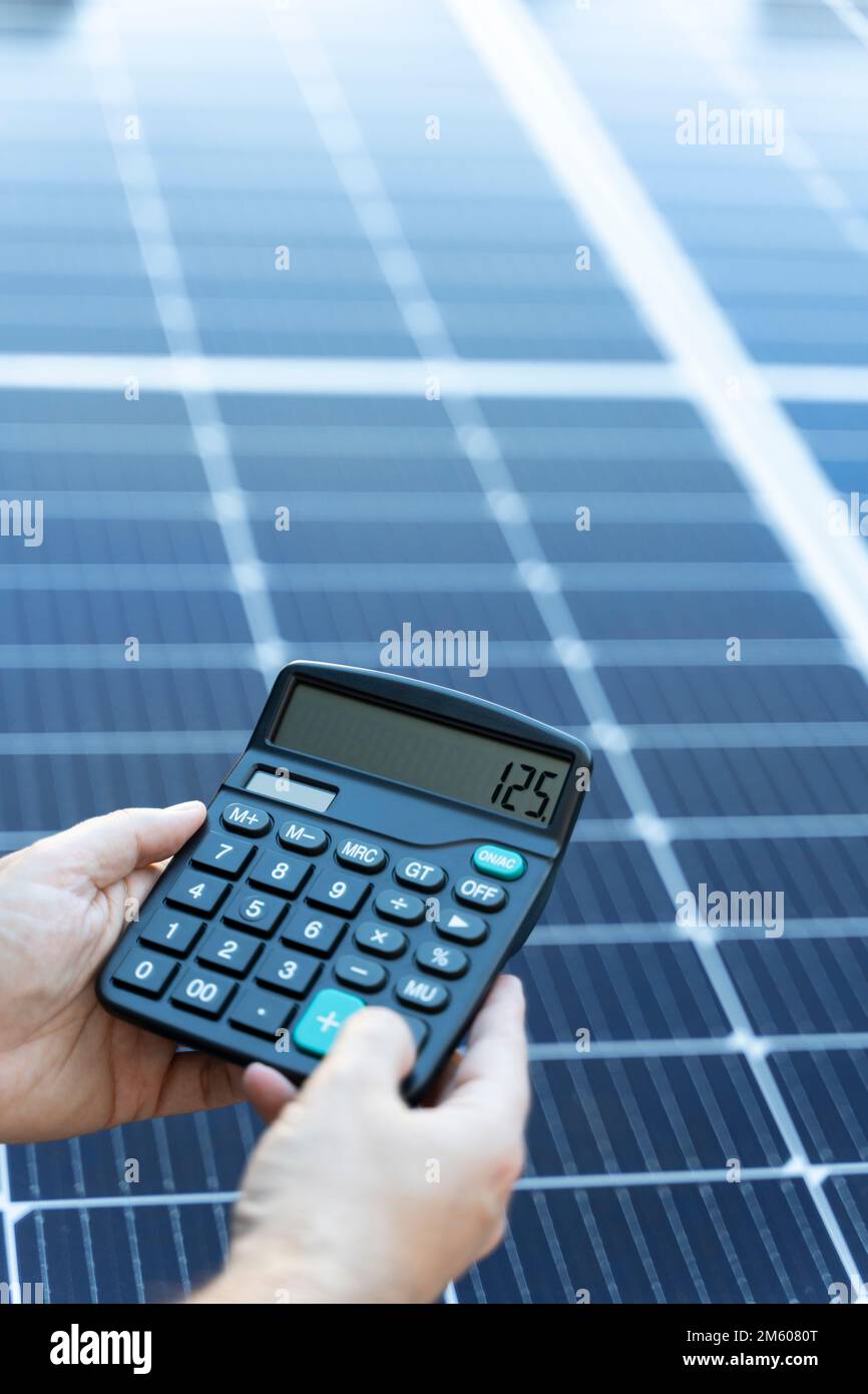 Concetto di risparmio energetico con pannelli solari e calcolatrice Foto Stock