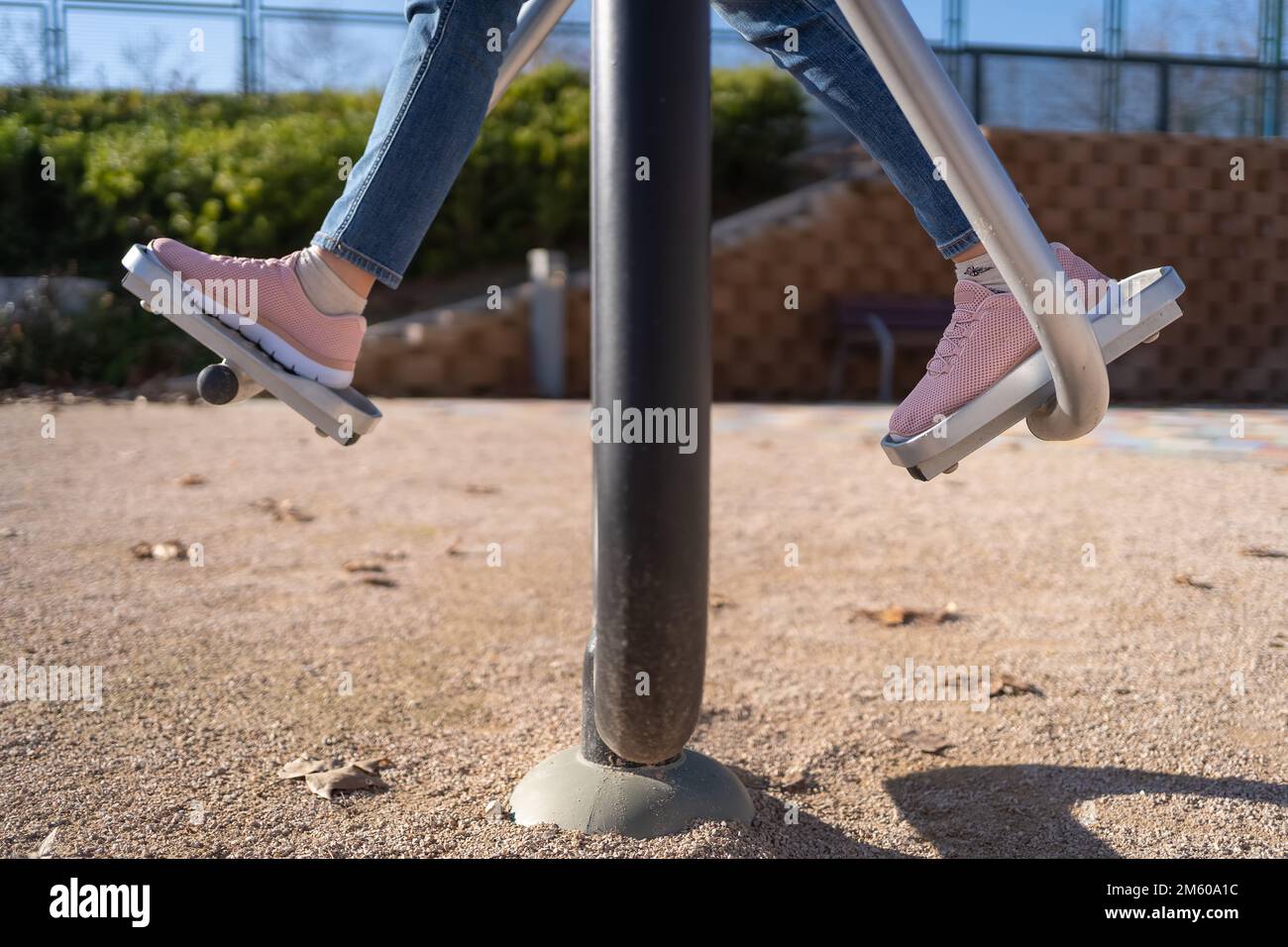 Particolare dei piedi delle donne che esercitano su un apparecchio di ginnastica sulla strada di accesso pubblico. Foto Stock