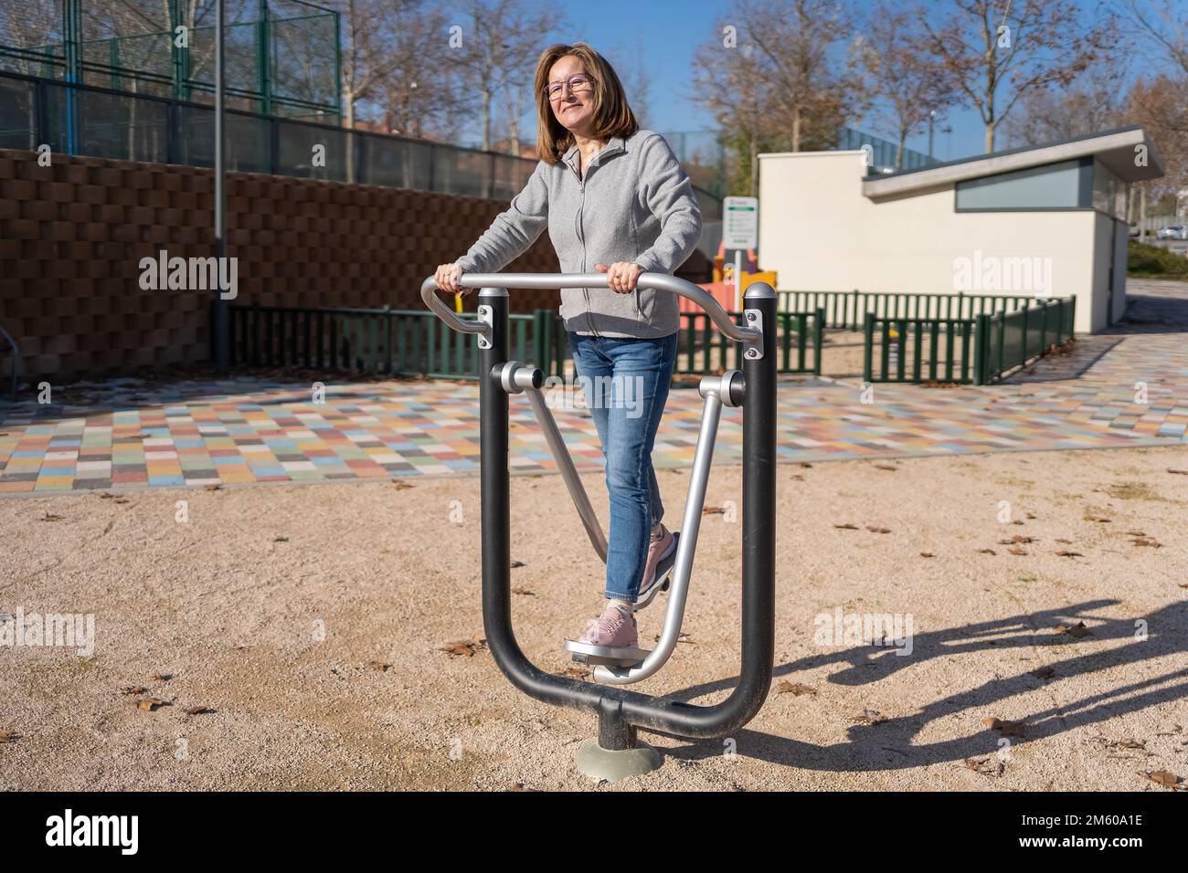 Donna anziana che si esercita in un parco pubblico per mantenersi in forma in modo sano. Foto Stock