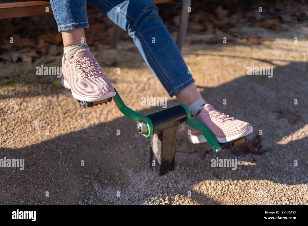 Particolare della pedalata dei piedi delle donne su un apparecchio di ginnastica in un parco pubblico. Foto Stock