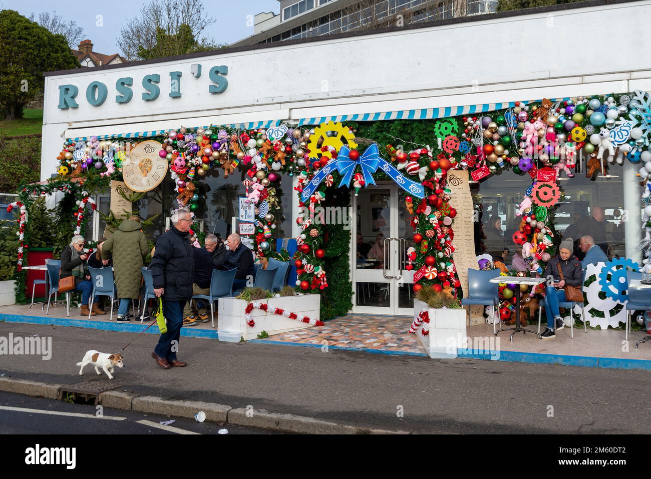 Western Esplanade, Southend on Sea, Essex, Regno Unito. 1st Jan, 2023. La gente è fuori a godersi il clima mite di Capodanno lungo il lungomare di Southend, con alcuni pasti fuori dalla gelateria Rossi con le sue colorate decorazioni natalizie Foto Stock