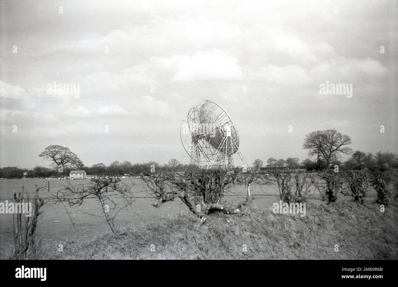 Alla fine del 1950s, una vista storica del telescopio Mark i o Lovell, Cheshire, Inghilterra, Regno Unito, il più grande radiotelescopio al mondo quando fu costruito nel 1957. Il radiotelescopio prende il nome da Bernard Lovell, un radioastronomo dell'Università di Manchester, che nel 1945 istituì un osservatorio - l'osservatorio della Jodrell Bank - nell'Inghilterra nordoccidentale per indagare sui raggi cosmici, continuando il lavoro che aveva intrapreso sul radar durante la seconda guerra mondiale. Nel 1988 il Telescopio Lovell è stato costruito come edificio classificato di primo grado, il che significa che è un edificio di "eccezionale interesse". Foto Stock