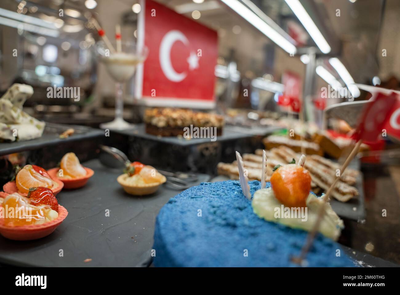 Primo piano di torta blu a metà mangiata guarnita con frutta a buffet Foto Stock