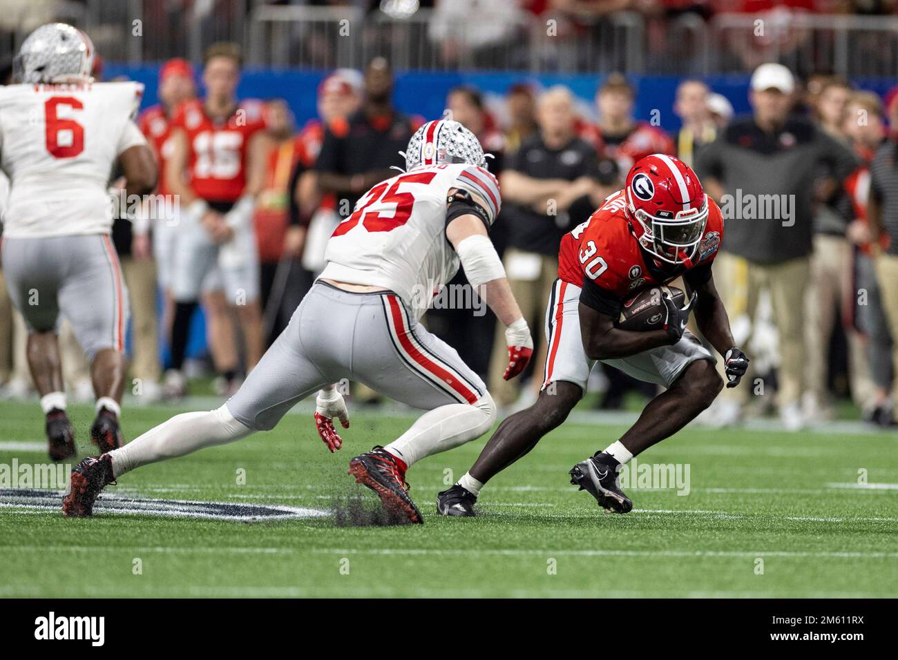 Atlanta, Georgia. 31st Dec, 2022. Georgia running back Daijun Edwards (30) corre con la palla come Ohio state linebacker Tommy Eichenberg (35) persegue durante la partita di calcio NCAA tra l'Ohio state Buckeyes e la Georgia Bulldogs al Mercedes-Benz Stadium di Atlanta, Georgia. La Georgia ha sconfitto l'Ohio state 42-41. John Mersits/CSM/Alamy Live News Foto Stock