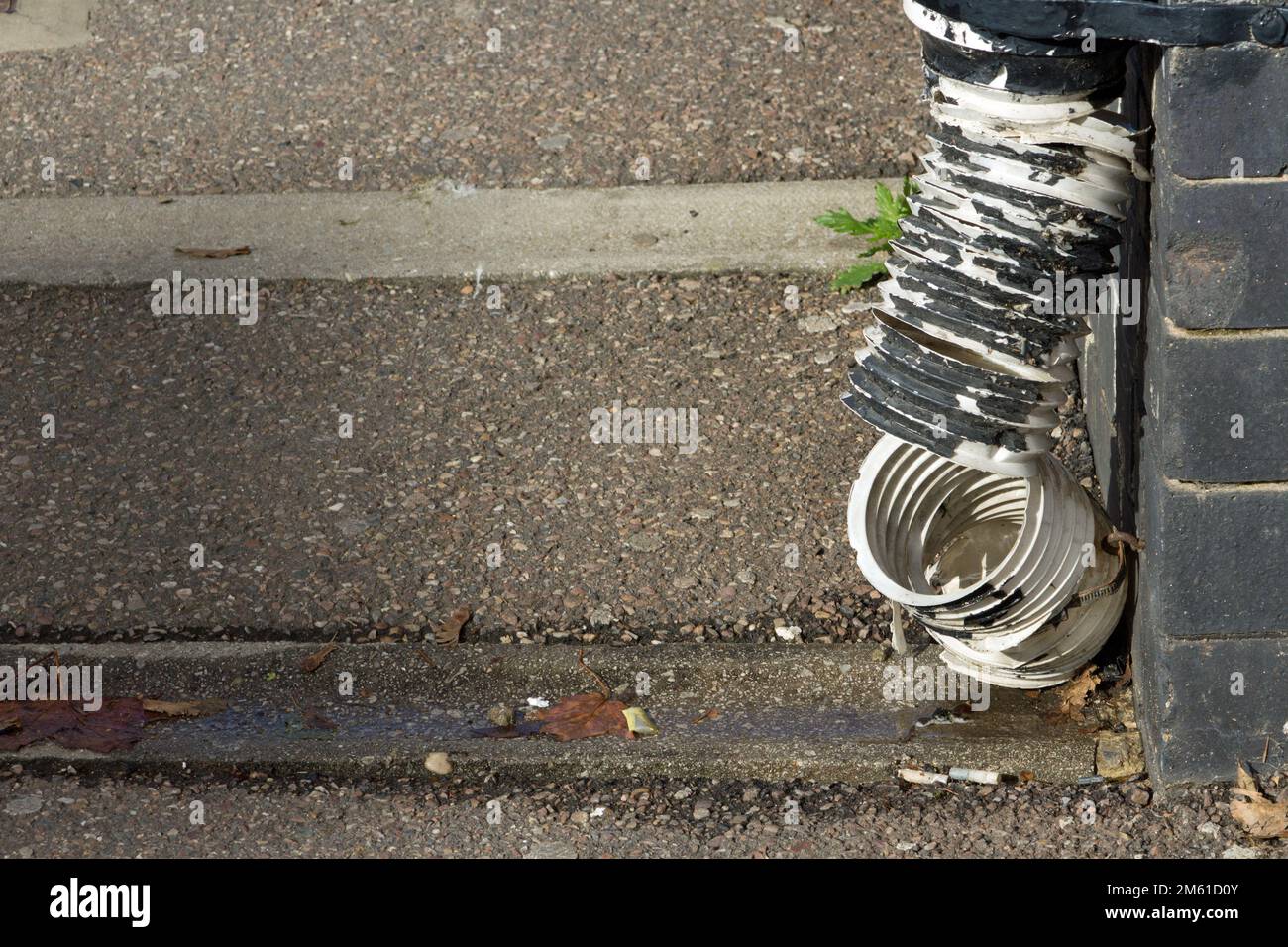 rottura del tubo di plastica attaccato ad una parete Foto Stock