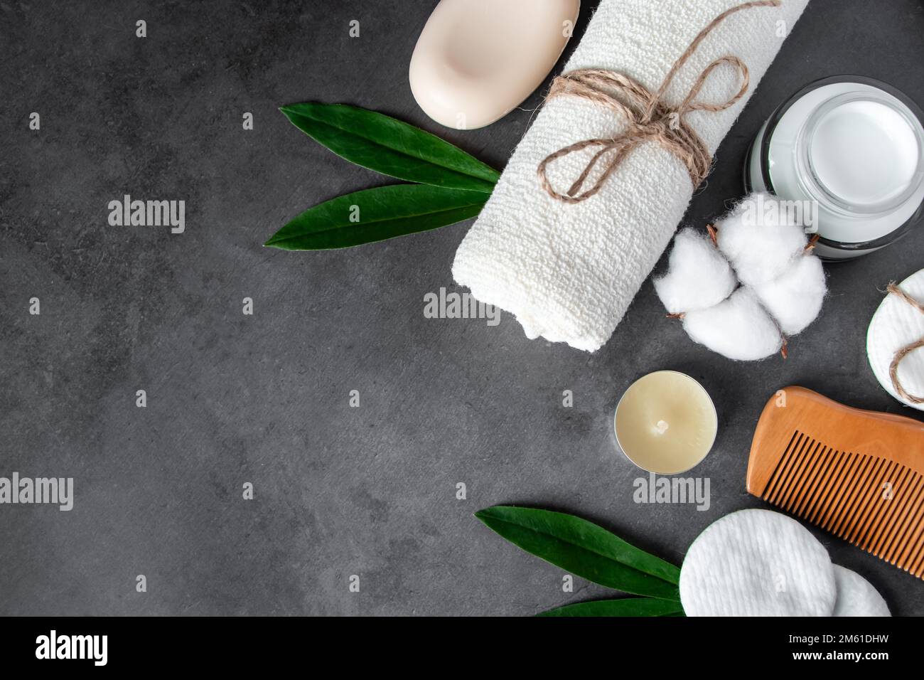 Cosmetici naturali per la cura del corpo su sfondo concreto. Accessori per il centro benessere, asciugamano, spazzola per capelli, olio essenziale. Composizione della disposizione piatta. Prodotti ecologici, Zer Foto Stock