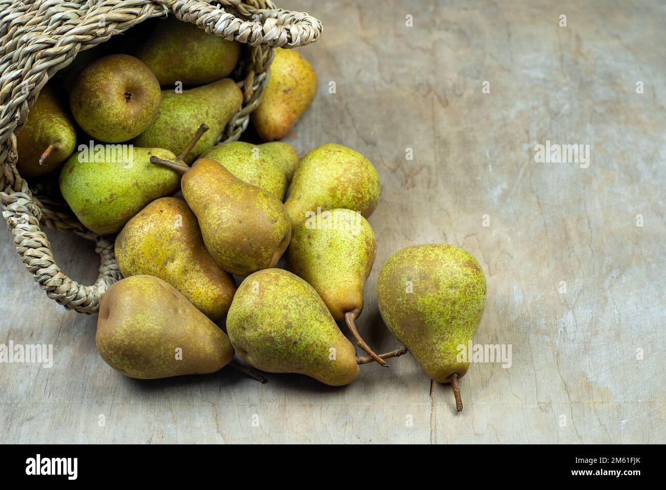 Pere in cesto su uno sfondo di legno. Raccolta di frutta. Autunno ancora vita. Pear Variety Bera Conference. Cibo vitaminico. Foto Stock